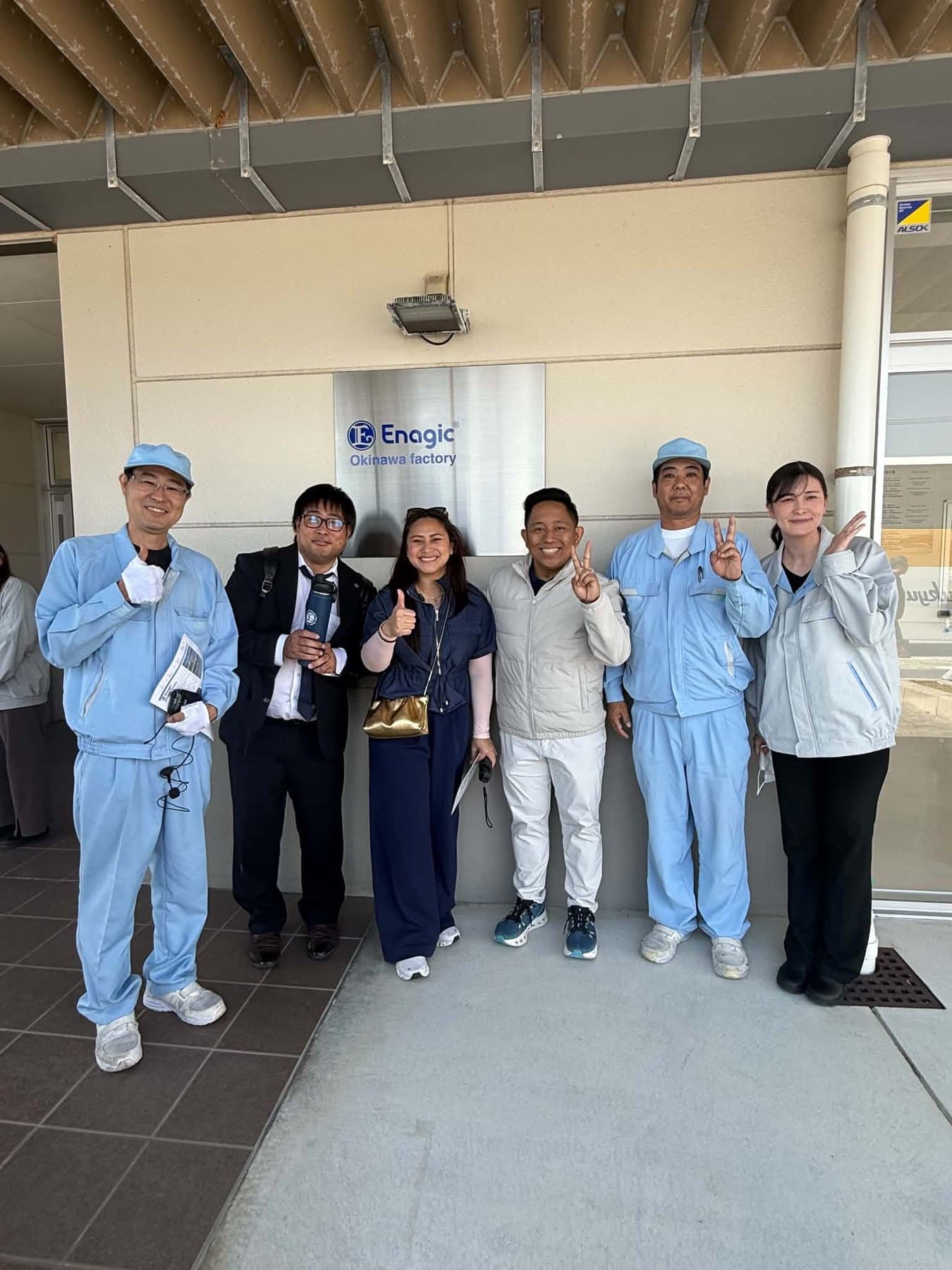 Visitors and staff at the entrance to the Enagic Okinawa factory