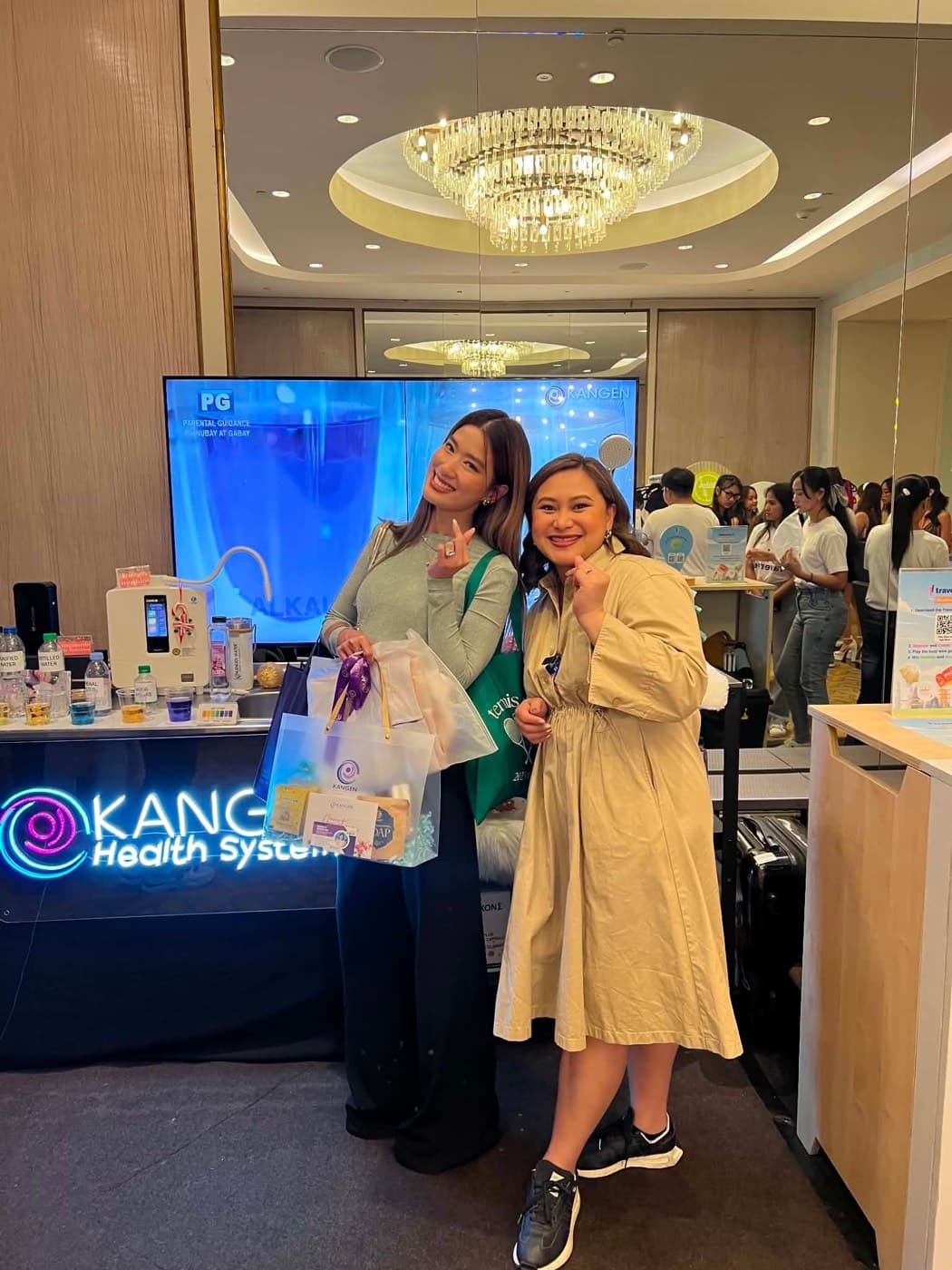 Two people at a Kangen Health System demonstration booth, the Leveluk K8 on the counter