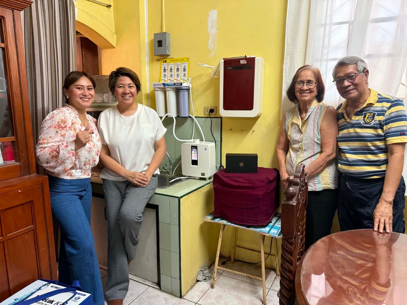 Four people with a Leveluk K8 installed on a green-tiled counter