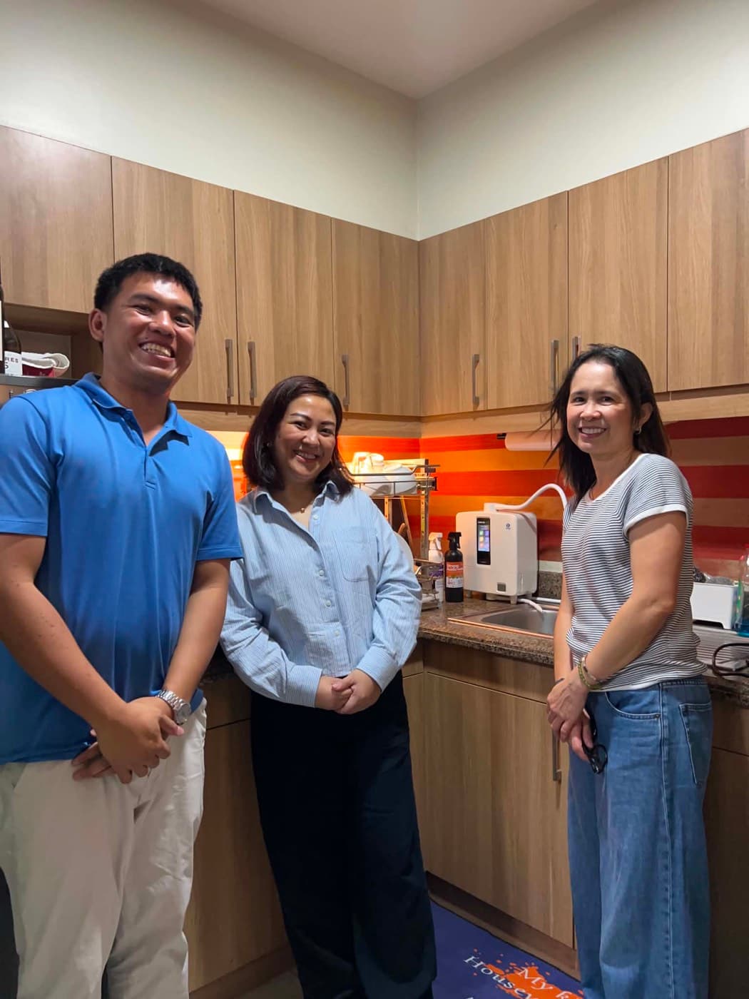 Three people beside a Leveluk K8 on a granite kitchen counter